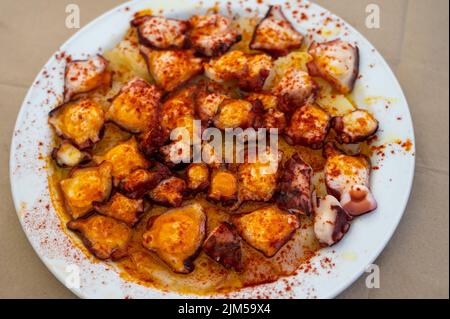 Gustosi frutti di mare, polpo alla griglia in stile galiziano con paprika pimento rosso e patate serviti nel ristorante spagnolo Foto Stock