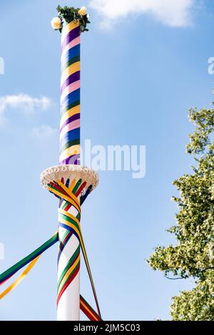 Uno scatto verticale di corde colorate su un tradizionale Maypole inglese Foto Stock