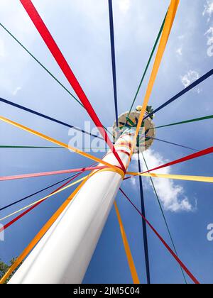Un tiro verticale ad angolo basso di corde colorate su un tradizionale Maypole inglese Foto Stock