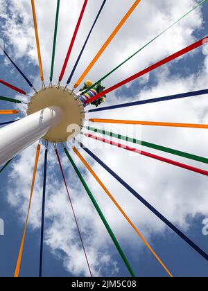Un tiro verticale ad angolo basso di corde colorate su un tradizionale Maypole inglese Foto Stock