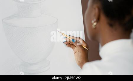 Giovane studente disegno vaso su tela bianca e cavalletto in classe d'arte. Donna creativa usando la matita per disegnare il disegno sulla carta e sviluppare le abilità artistiche per la crescita. Primo piano. Scatto portatile Foto Stock