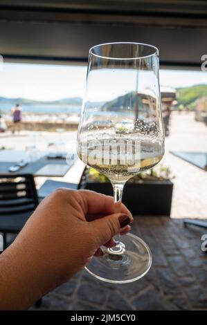 Bere txakoli o Chacolí vino bianco leggermente frizzante molto secco prodotto nei Paesi Baschi spagnoli, servito nel ristorante di Getaria pescatore Foto Stock