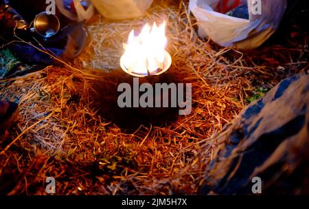 Primo piano bruciare gas di campo su erba secca di notte Foto Stock