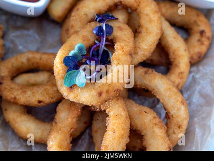 anelli di cipolla fritti con altri prodotti nel caffè Foto Stock