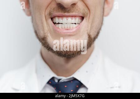 Primo piano di bocca maschile con allineatori chiari sui denti Foto Stock
