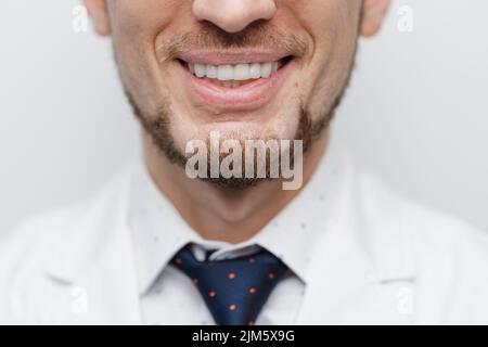 Primo piano di bocca maschile con allineatori chiari sui denti Foto Stock
