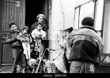 Una foto in scala di grigi di una famiglia di fronte al loro edificio a Istanbul, Turchia Foto Stock