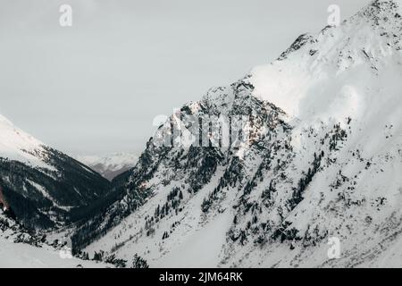 Una vista pittoresca delle montagne innevate in una giornata gelosa. Foto Stock