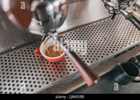 Vista ravvicinata della preparazione del caffè espresso in una macchina da caffè automatica nel caffè Foto Stock