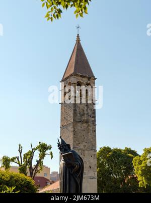 Uno scatto verticale della Statua di San Gregorio di Nin e del campanile della Cappella del Santo Arnir contro il cielo blu a Spalato, in Croazia Foto Stock