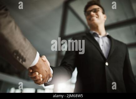 Sotto di due uomini d'affari si agitano durante una riunione in un ufficio. I colleghi finalizzano una promozione, un accordo e una fusione di successo. I colleghi salutano Foto Stock