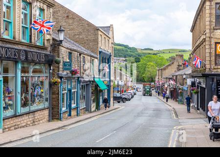 Ramsbottom Village a Bury, Manchester, vista dei negozi e degli affari su Bridge Street con trattore sulla strada, Lancashire, Inghilterra, estate 2022 Foto Stock