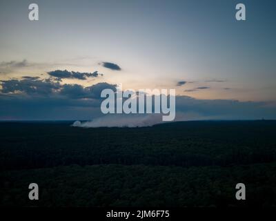 Berlino, Germania. 04th ago 2022. La nube di fumo sopra il sito di fuoco a Grunewald al tramonto, preso dal vicino insediamento forestale a Krummen Lanke (fucilato con il drone). Al mattino è scoppiato un incendio presso il sito di scoppio della polizia a Grunewald. A causa dell'incendio, le esplosioni si sono nuovamente verificate nelle prime ore della sera. Credit: Christian Ender/dpa/Alamy Live News Foto Stock