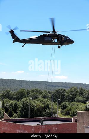 Soldiers with Headquarters and Headquarters Company, 1st battaglione, 110th reggimento fanteria, 28th divisione fanteria, dispiegano linee belay da un falco nero UH-60 della brigata aerea di combattimento 28th durante una missione di addestramento di rapelling a Fort Indiantown Gap, Pa., il 3 agosto 2022. I soldati hanno eseguito diverse gocce di rapel dal falco nero in un campo in preparazione per il dispiegamento sull'edificio. La pianificazione e la preparazione per l'addestramento verifica che i soldati siano pronti a svolgere il compito in modo sicuro e secondo gli standard. (STATI UNITI Foto dell'esercito dello staff Sgt. Brandon Nelson) Foto Stock