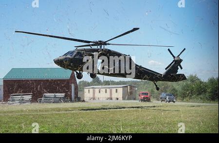 Soldati del 28th Expeditionary Combat Aviation atterrano un falco nero UH-60 per coordinare l'addestramento del rapel con i soldati della Headquarters and Headquarters Company, 1st Battaglione, 110th reggimento di fanteria, 2nd squadra di combattimento di Brigata di fanteria, a Fort Indiantown Gap., Pa. I piloti e gli equipaggi capi del falco nero coordinati con lo scout rapel master per condurre in sicurezza l'allenamento (U.S.A. Foto dell'esercito di Sgt. 1st Classe Matthew Keeler). Foto Stock