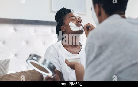 Il suo tempo di girare il significato della mascolinità intorno. Una coppia giovane che ottiene i facciali fatti in casa insieme nel paese. Foto Stock