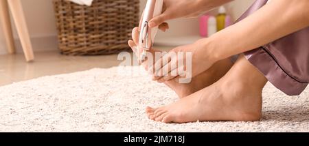 Giovane donna facendo pedicure a casa Foto Stock