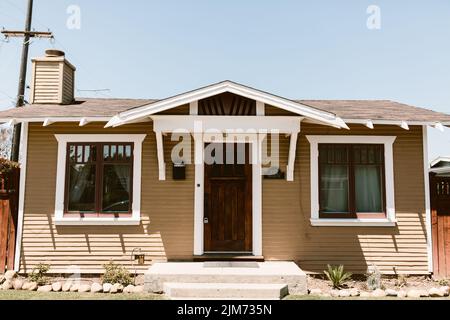 Una casa in stile artigiano marrone sotto un cielo blu Foto Stock