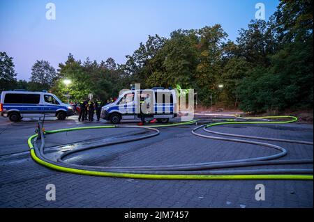 Berlino, Germania. 05th ago 2022. Gli agenti di polizia si trovano vicino alla scena del fuoco. Il giorno prima, un incendio scoppiò a Grunewald presso il sito di blasting della polizia di Berlino. Il sito di sabbiatura conserva munizioni che gli esperti di quel luogo normalmente rendono innocue. Credit: Christophe Gateau/dpa/Alamy Live News Foto Stock