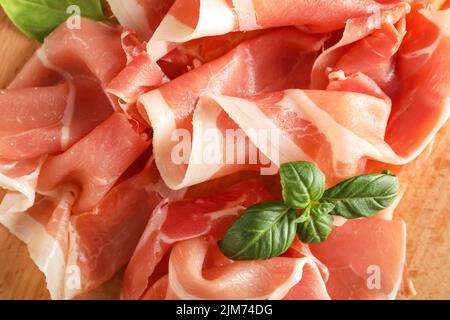 Asse di legno con fette di delizioso jamon, primo piano Foto Stock