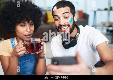 Abbiamo finito con una bella pittura e ricordi ancora migliori: Un uomo che tiene il cellulare mentre si siede a casa con la sua ragazza. Foto Stock