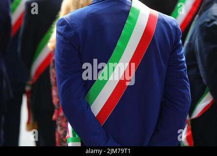 Il sash tricolore del sindaco vestito elegantemente durante una manifestazione con molti sindaci in Italia Foto Stock