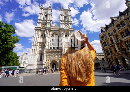 Turismo a Londra, Regno Unito. Vista posteriore della ragazza turistica che visita l'Abbazia di Westminster in giornata di sole a Londra, Inghilterra. Foto Stock