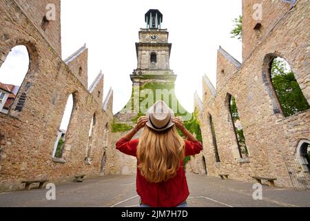 Turismo in Germania. Giovane donna turistica visitando le rovine della chiesa di Aegidienkirche distrutta durante il bombardamento della seconda guerra mondiale a Hannover Foto Stock