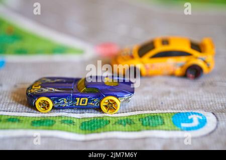 Un primo piano di un'auto futuristica del modello giocattolo Mattel Hot Wheels con il numero 10 su un tappetino da strada Foto Stock