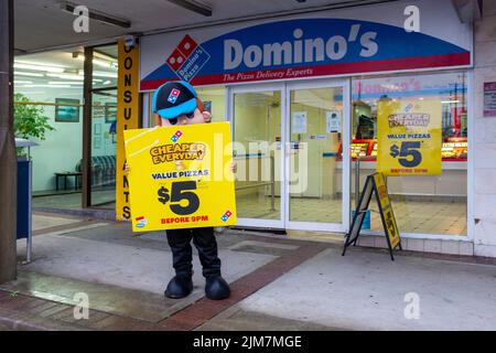 Un lavoratore in uniforme che promuove il commercio per Domino's Pizza presso la sede del negozio sulla costa nord del NSW Foto Stock
