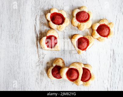 Biscotti di pasta sfoglia a forma di cuore pieni di fragole. Dessert party Foto Stock