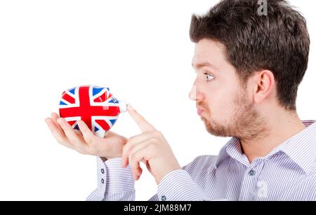 Uomo britannico che gioca con la banca del piggy Foto Stock