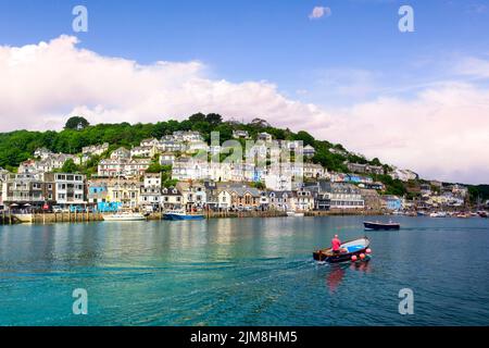 6 giugno 2018: Looe, Cornovaglia, Regno Unito - la piccola città costiera di Looe, con il fiume Looe e case collinari. Barca che attraversa il porto. Foto Stock