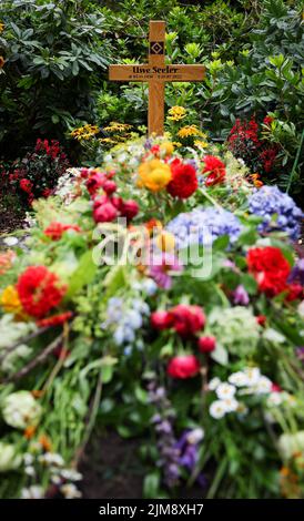 Amburgo, Germania. 05th ago 2022. Una croce di legno si erge sulla tomba della leggenda del calcio Uwe Seeler. Lo sportivo popolare è stato sepolto il 04 agosto nel più vicino circolo di famiglia al cimitero di Ohlsdorf. Uwe Seeler morì il 21.07.2022 all'età di 85 anni. Credit: Christian Charisius/dpa/Alamy Live News Foto Stock