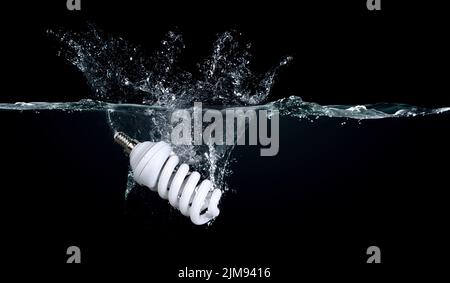 Schizzi d'acqua creativi su una lampadina a LED Foto Stock