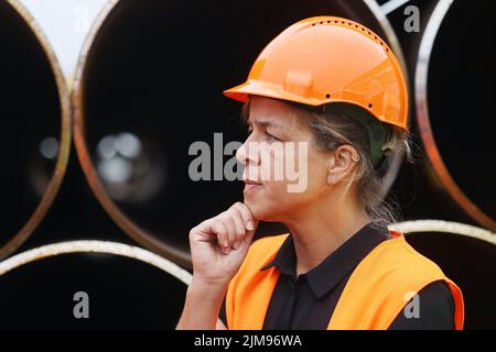 Hamm, Germania. 05th ago 2022. Mona Neubaur (Greens), ministro dell'economia nella Renania settentrionale-Vestfalia, si trova di fronte ai tubi d'acciaio della Mannesmann Line, di proprietà della Salzgitter AG. Lo stabilimento produce tubi per il collegamento al terminale LNG di Wilhelmshaven. Credit: Oliver Berg/dpa/Alamy Live News Foto Stock