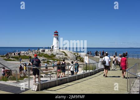 Peggy’s Cove, Canada - 31 luglio 2022: La gente guarda il famoso faro di Peggy’s Cove. Una piattaforma di osservazione in legno è stata installata nel 2021 per dare peopl Foto Stock