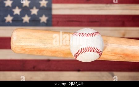 Palla che colpisce pipistrello di legno con pannelli sbiaditi dipinti in colori American USA bandiera Foto Stock