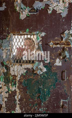 Uomo anziano dietro la porta bloccata in cella Foto Stock