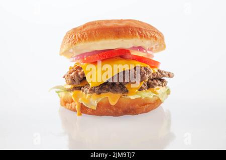 Cheeseburger brioche a due piani con pomodori al formaggio e cipolla. Foto Stock