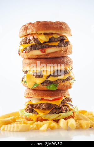 Hamburger brioche da ciambella da buongustai accatastati l'uno sull'altro con patatine fritte. Foto Stock