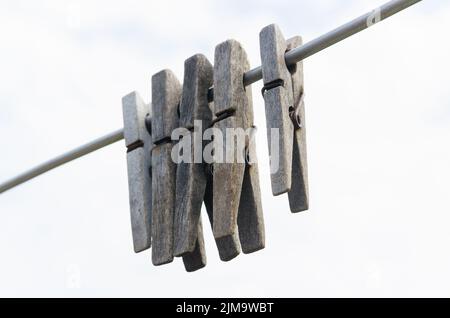 Vecchi chiodi di garofano di legno appesi alla corda Foto Stock
