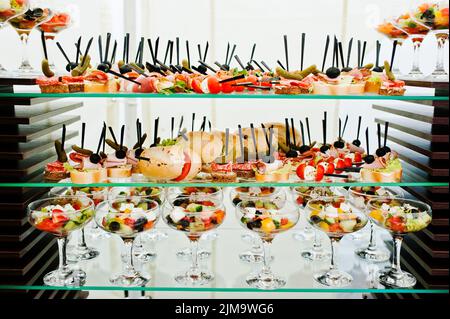 Buffet al tavolo della reception con hamburger, spuntini freddi, carne e insalate Foto Stock