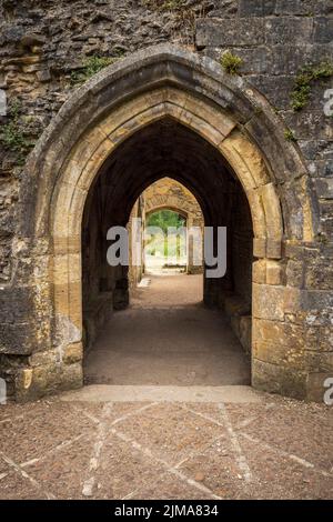 Attraverso le porte ad arco delle rovine di Minster Lovell Hall, Cotswolds, Oxfordshire, Inghilterra Foto Stock