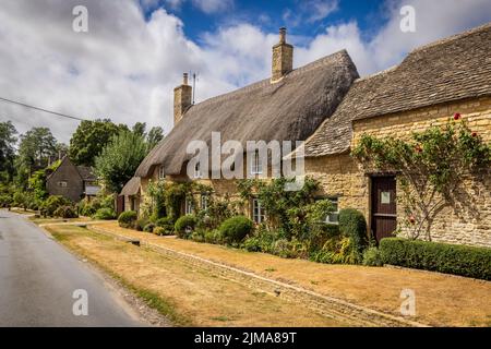 Un cottage con tetto in paglia a Minster Lovell nel Cotswolds, Oxfordshire, Inghilterra Foto Stock