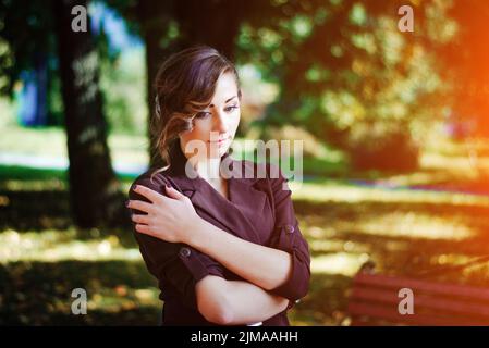 Ritratto di ragazza intelligente con un vecchio stile acconciatura outdoor in cappotto marrone in autunno. Foto Stock