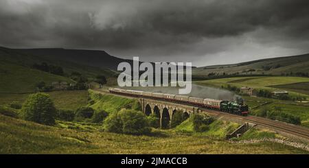 70000 la locomotiva a vapore Britannia che attraversa il Viadotto di Lunds sulla Settle-Carlisle Railway con uno sfondo di Wild Boar cadde. Foto Stock