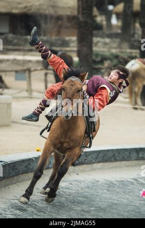 Partecipante a l'atto equestre si comporta, una breve routine a cavallo acrobatica eseguito Foto Stock