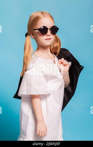 Una bambina con vestito bianco e scarpe nere Foto Stock