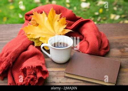 Tazza di tè sul tavolo con una sciarpa e un mucchio di libri Foto Stock